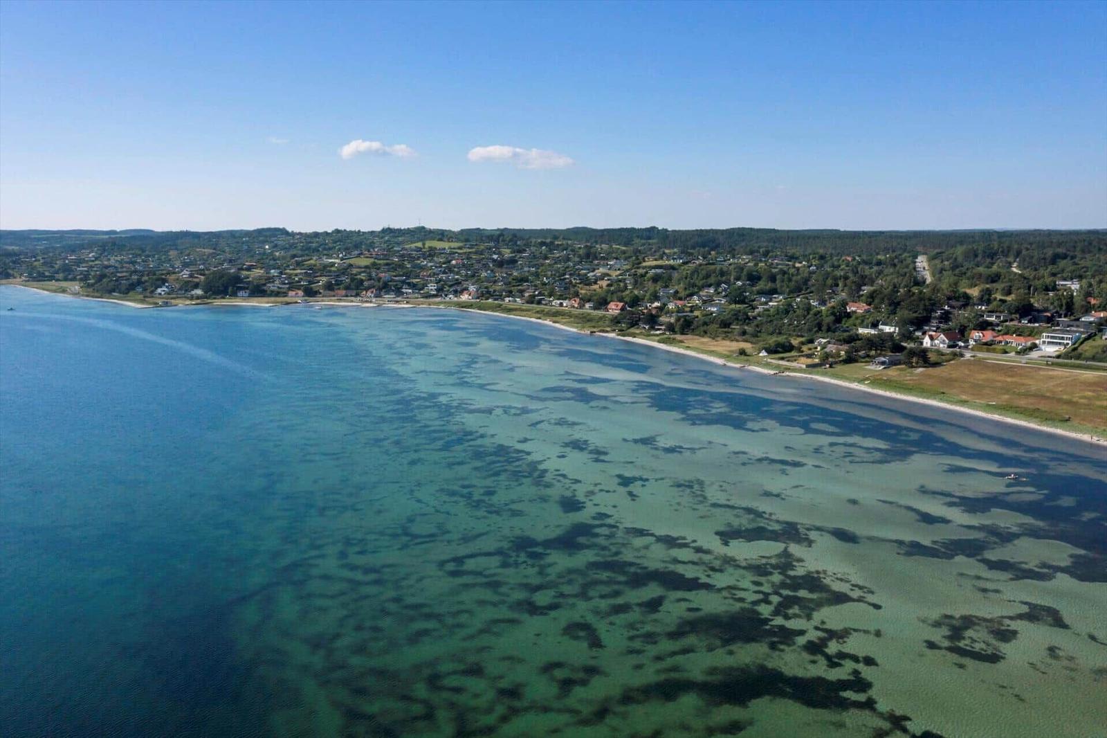 Aerial view of a coastal town with clear water and sandy beach.