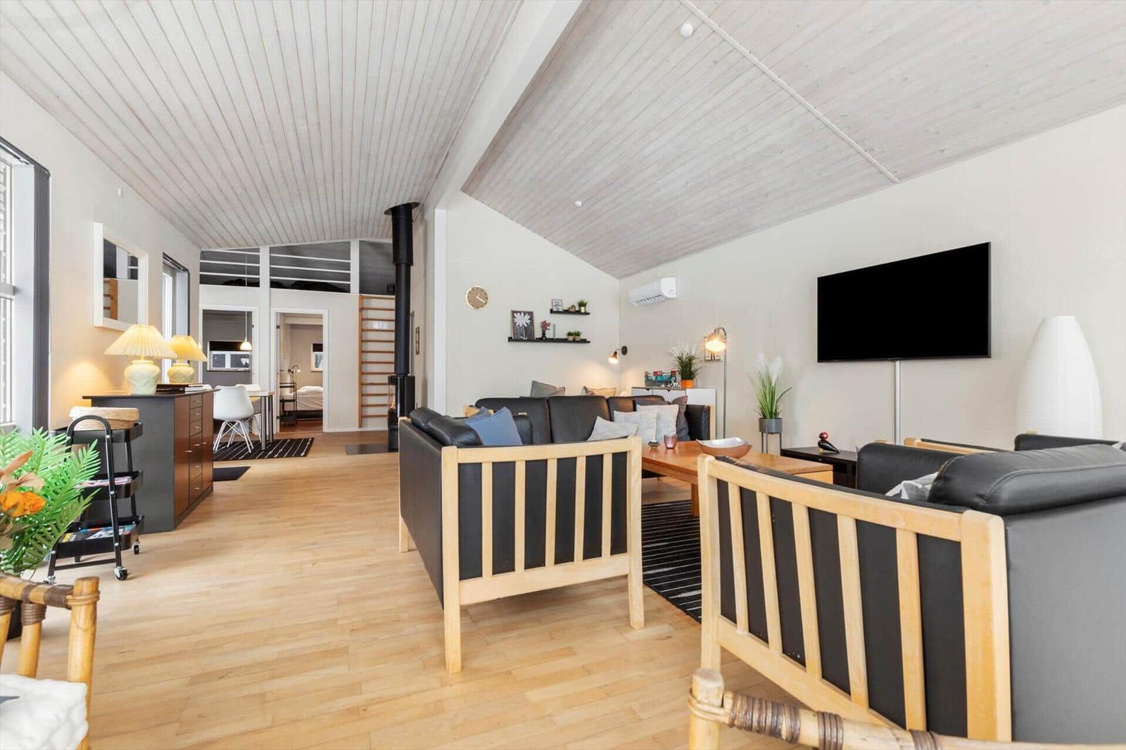 Wohnbereich mit zwei Sofas, Holzboden und Fernseher an der Wand.