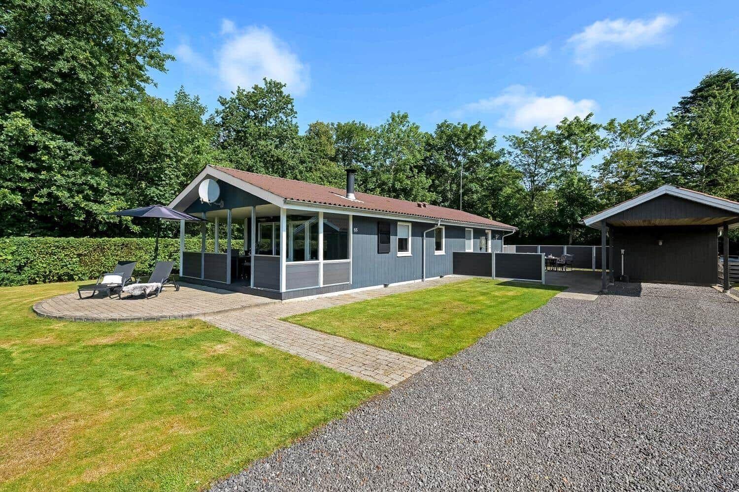 Moderne Ferienwohnung mit Terrasse, Garten und Grillplatz. Umgeben von Bäumen und Grün.