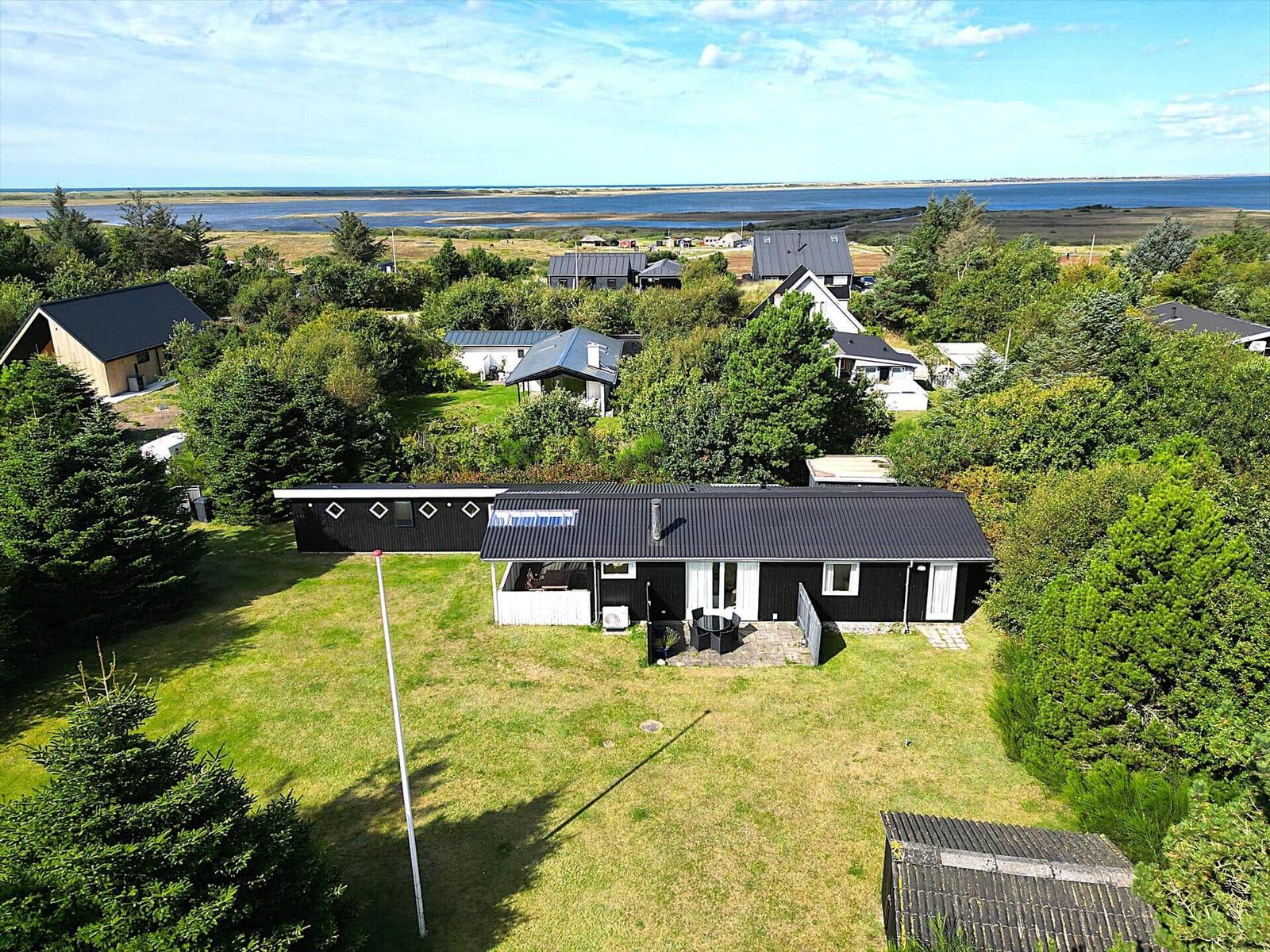 Schwarzes Haus mit Garten und Blick auf Wasser