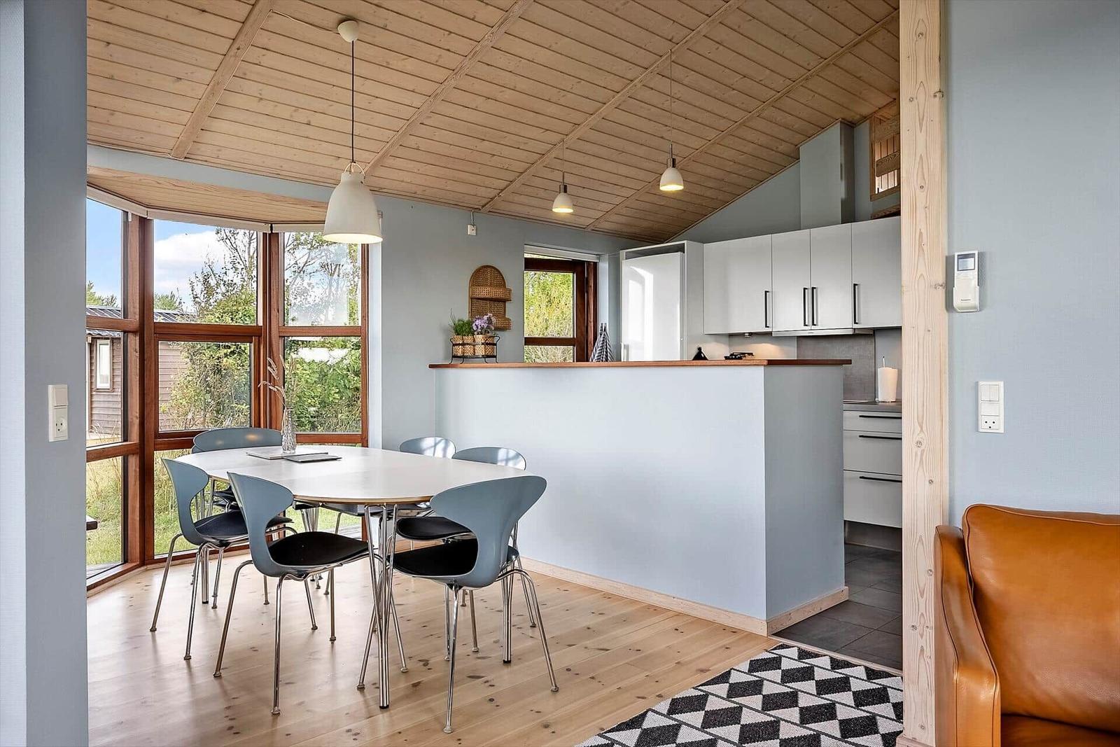 Essbereich mit Tisch und Stühlen, Küche mit Arbeitsplatte und Fenster.