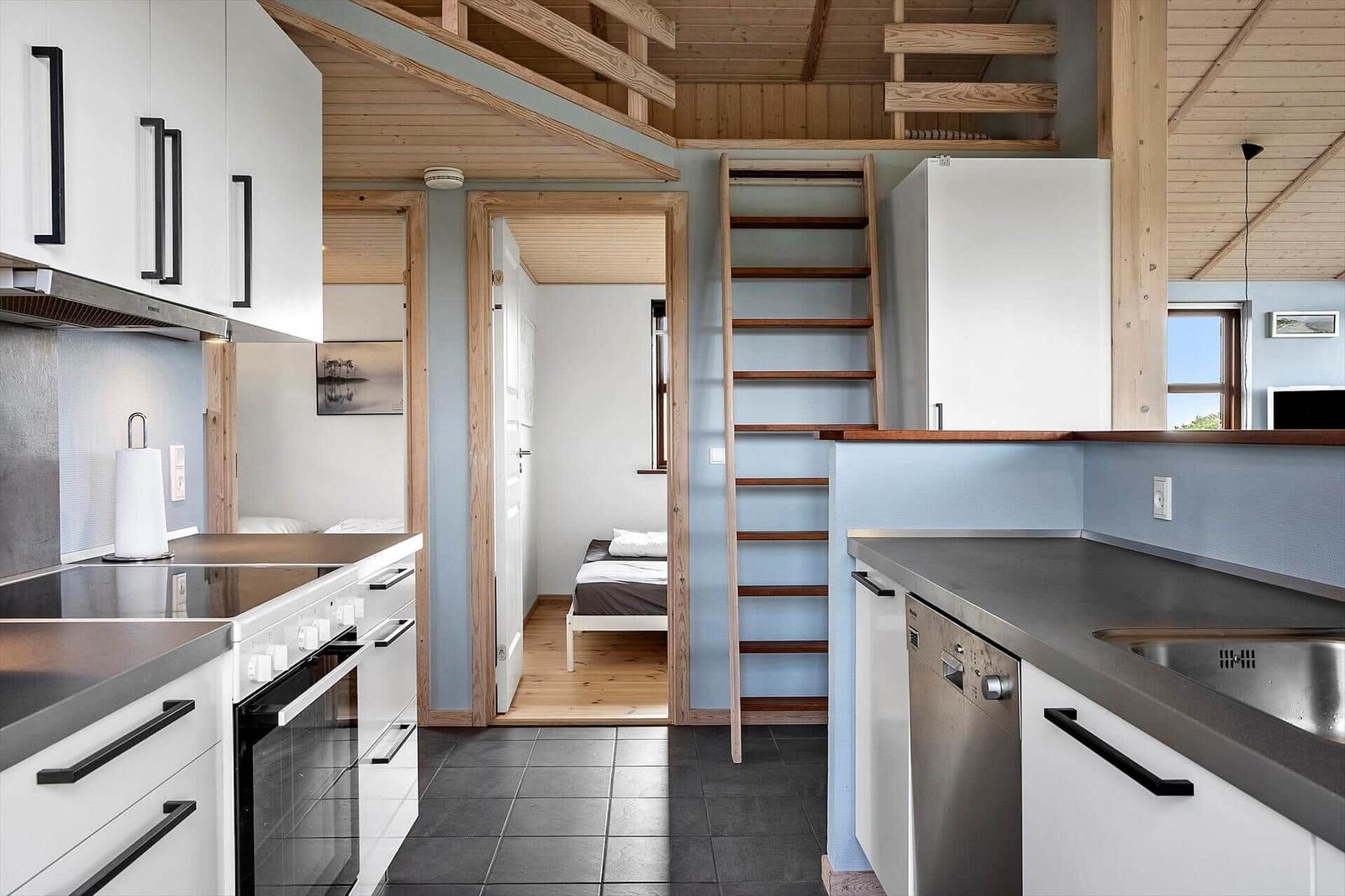 Küche mit Schlafzimmer und Holztreppe. Moderne Einrichtung und Holzdecke.