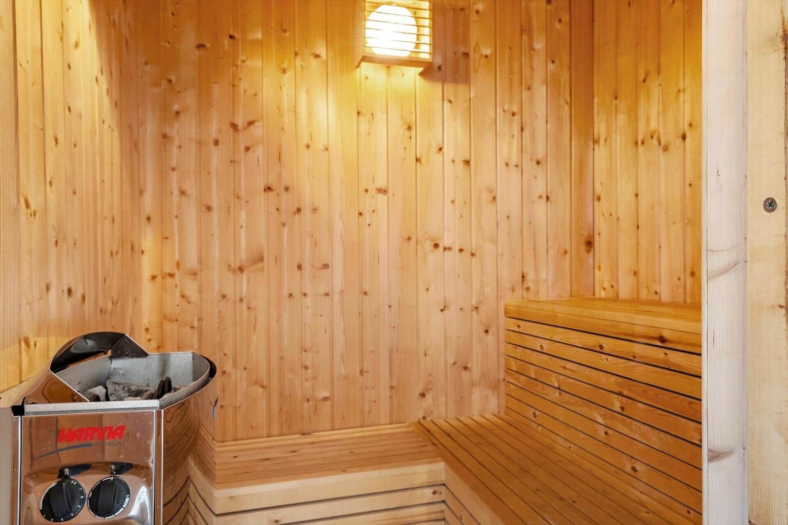 Sauna with wooden walls, benches, and heater.
