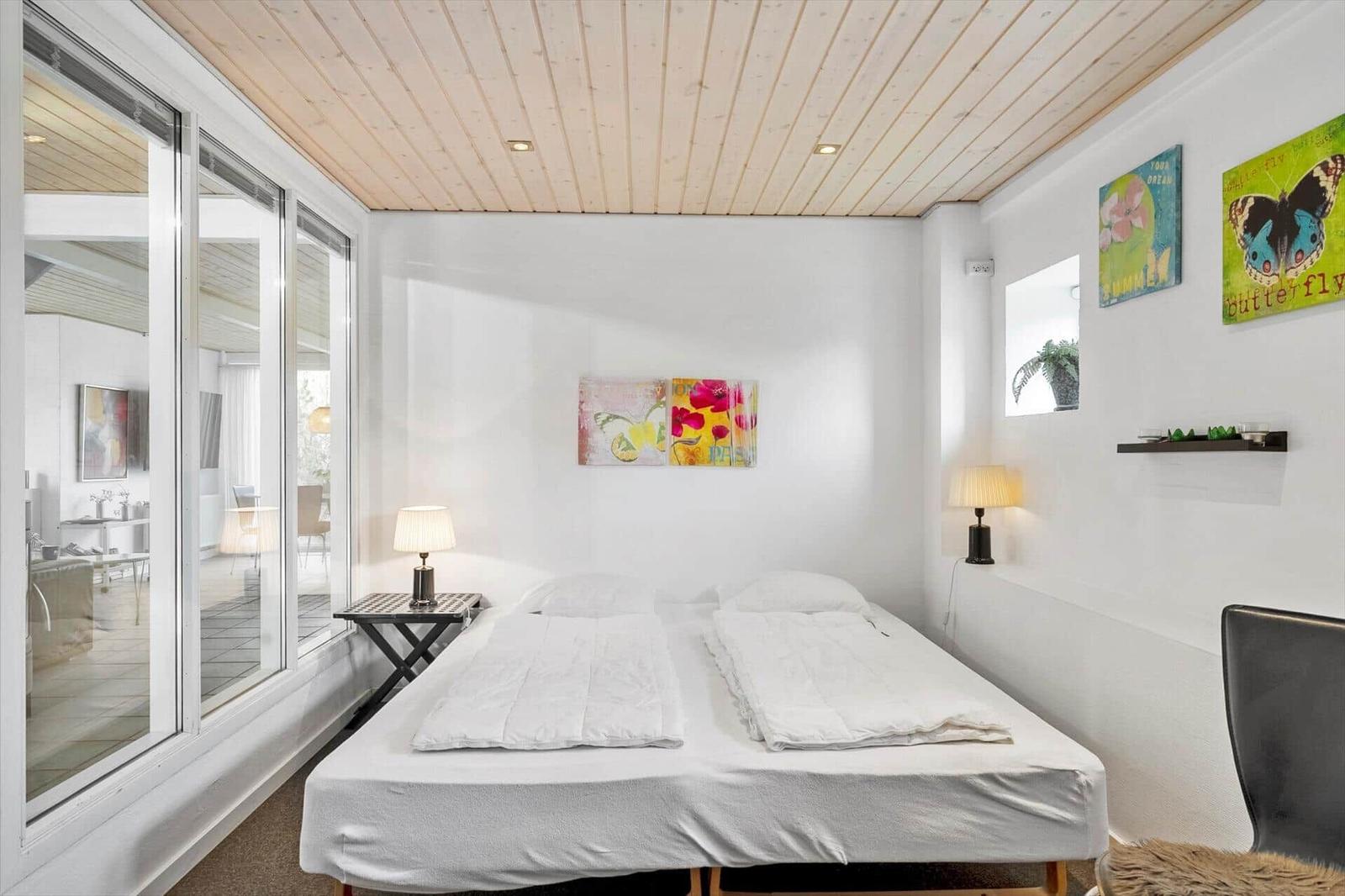 Bedroom with double bed, glass doors, and wall art