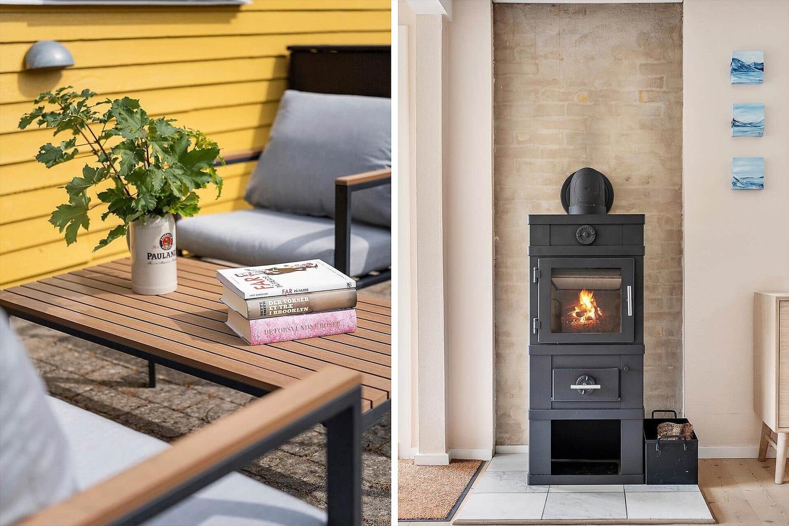 Außenbereich mit Tisch, Sitzgelegenheit und Pflanze. Innen: Kaminofen mit brennendem Holz.