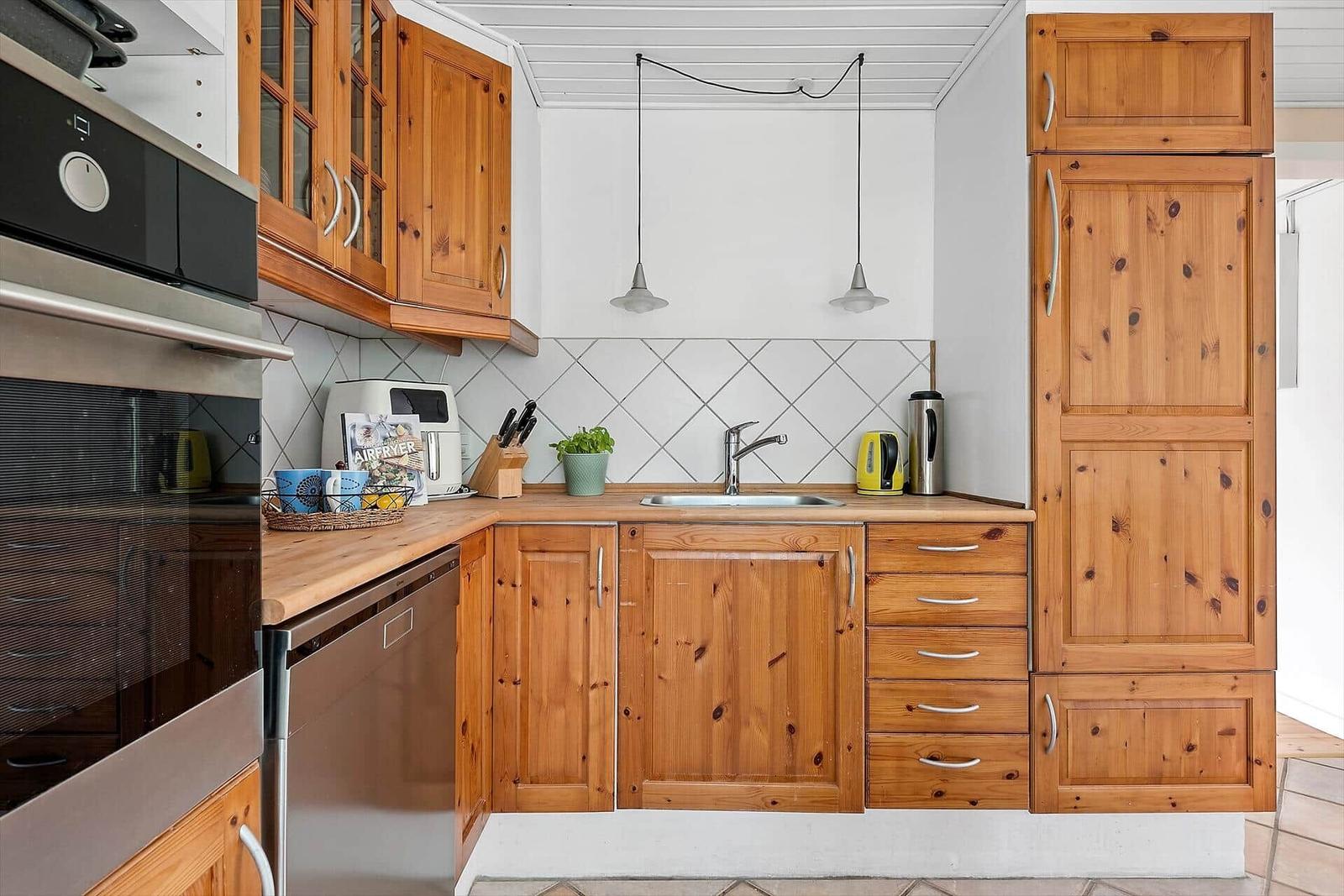 Küche mit Holzschränken, Spüle und Küchengeräten