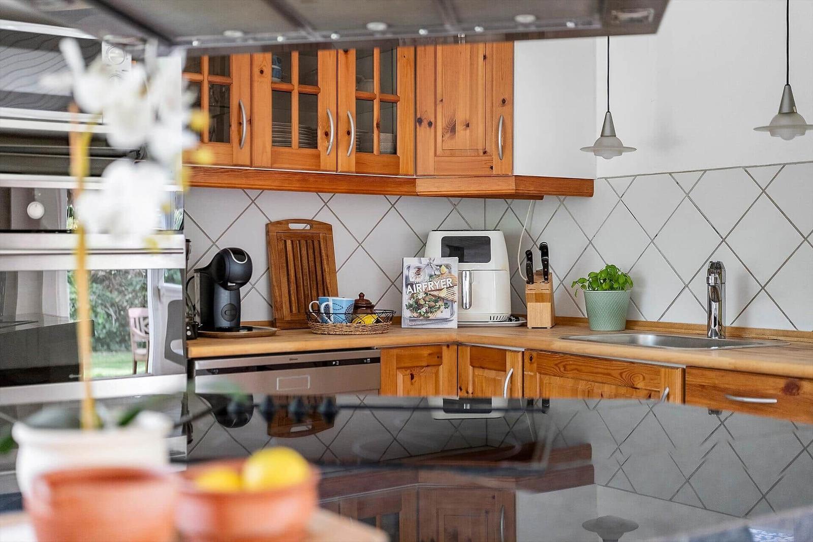 Küche mit Holzschränken, Spüle und Küchenzeile