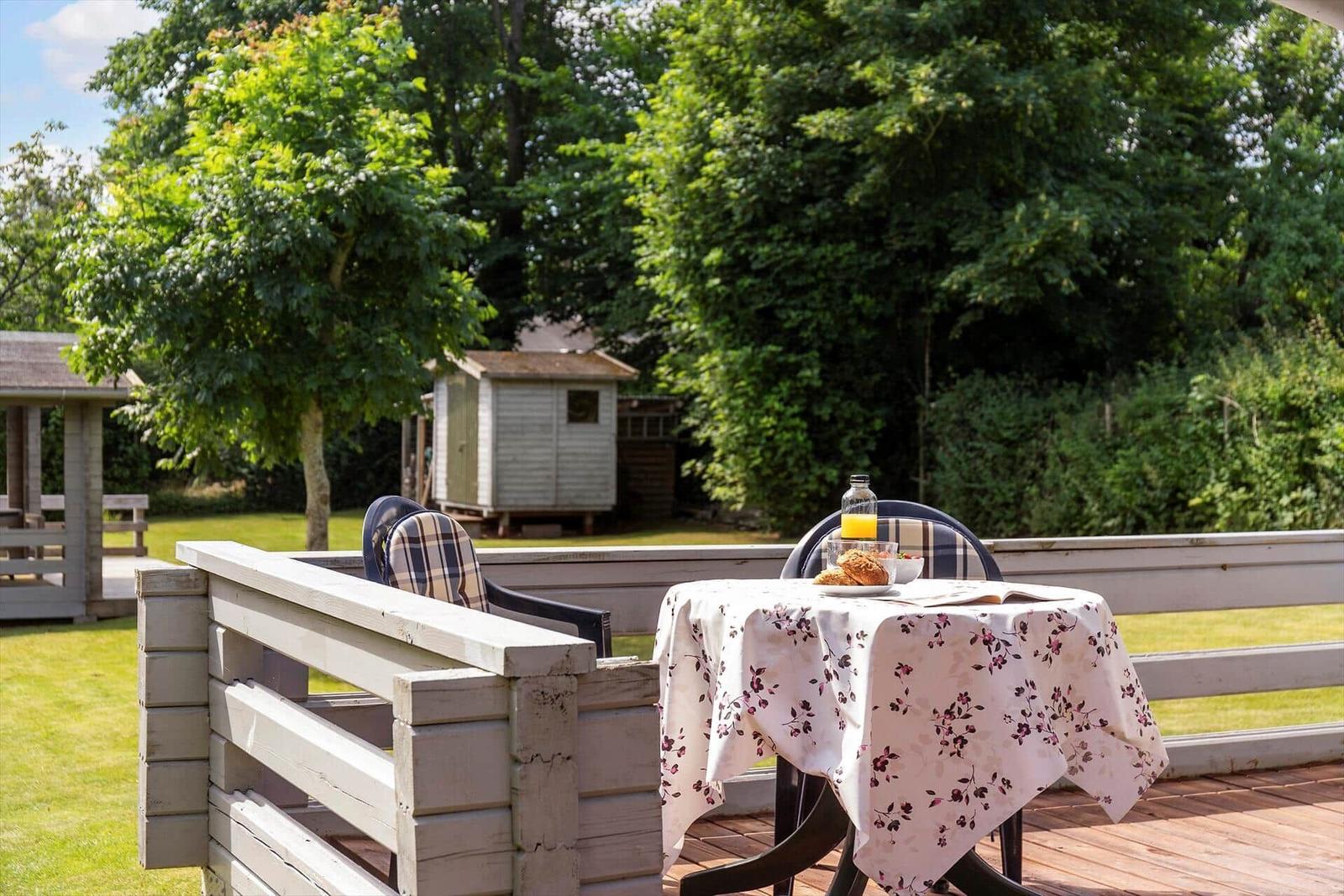 Tisch mit Tischdecke und Frühstück auf der Terrasse.
