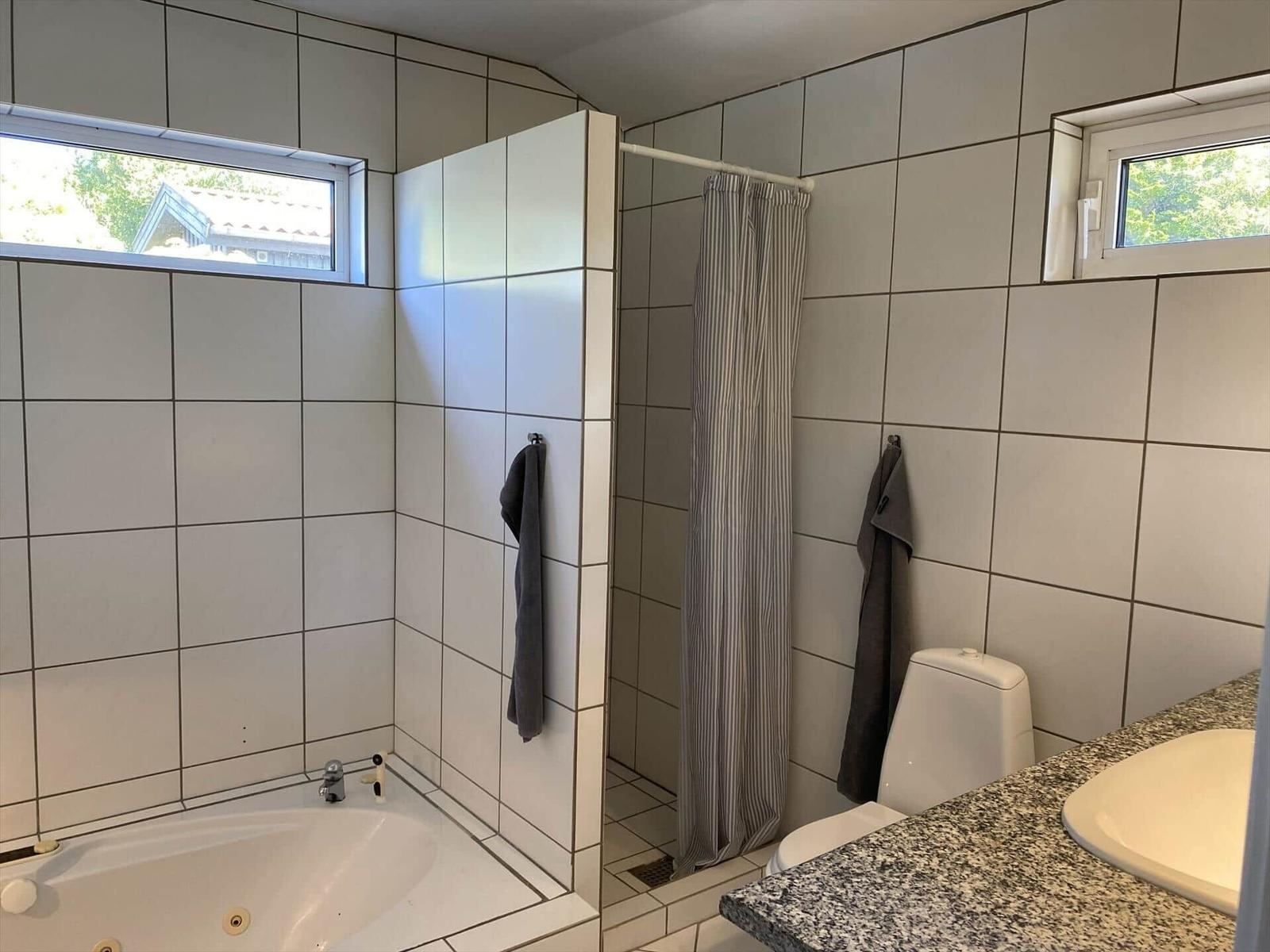 Badezimmer mit Badewanne, Dusche und Waschbecken.