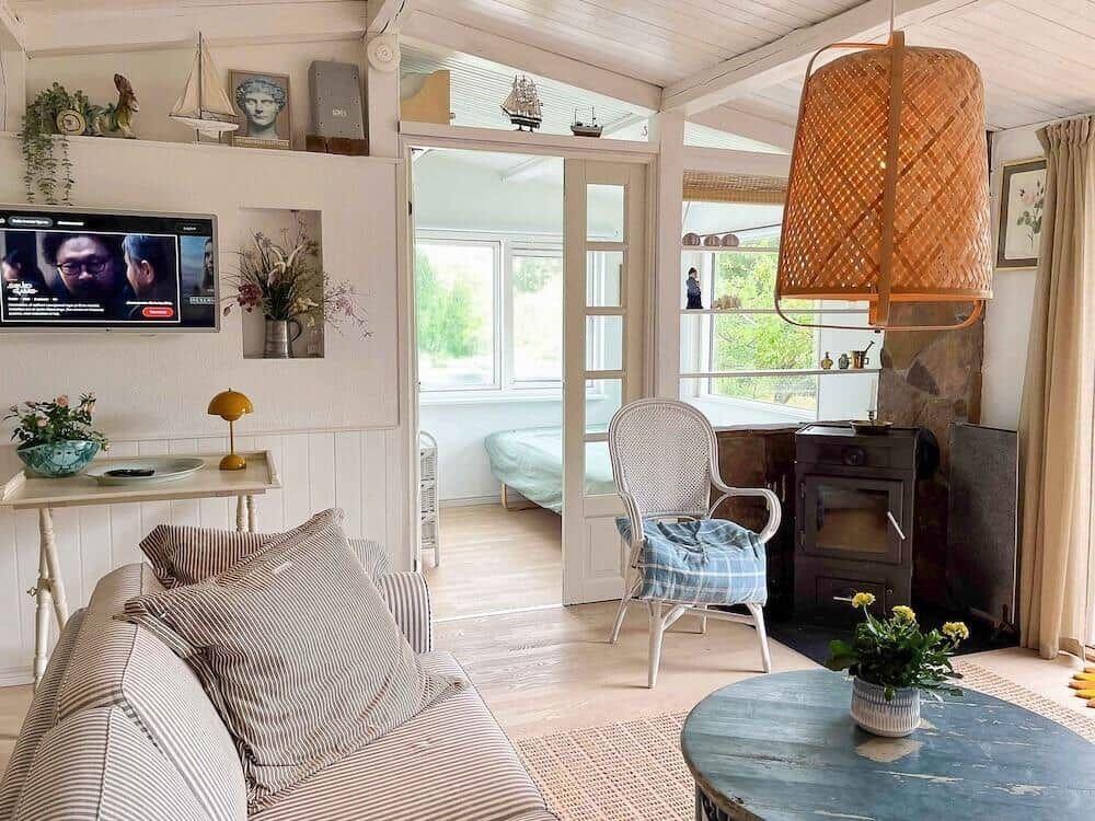 Wohnzimmer mit Sofa, Fernseher und Sitzgelegenheit. Durchgang zur Schlafzimmer.