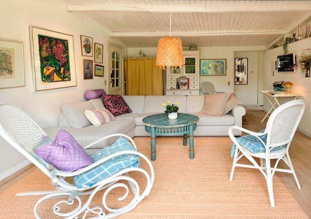 Wohnzimmer mit Sofa, Stühlen und Deckenventilator.