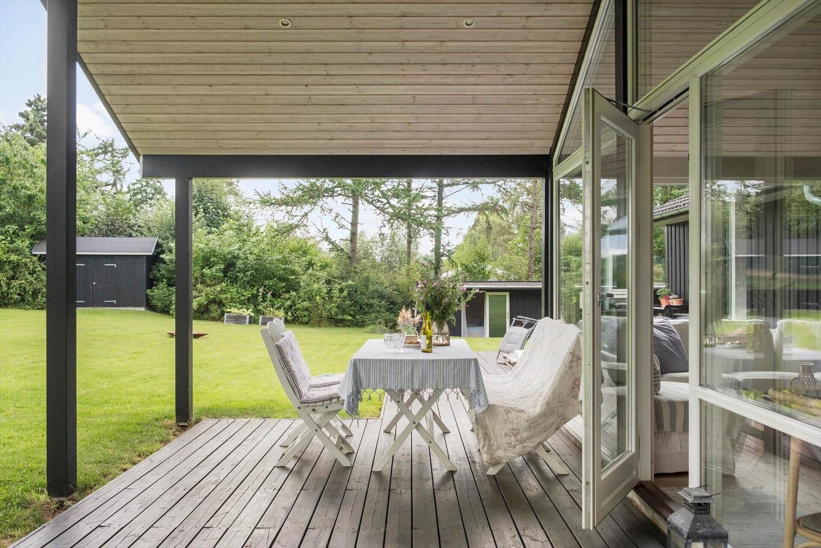 Terrasse mit Tisch, Stühlen und Blick auf den Garten.