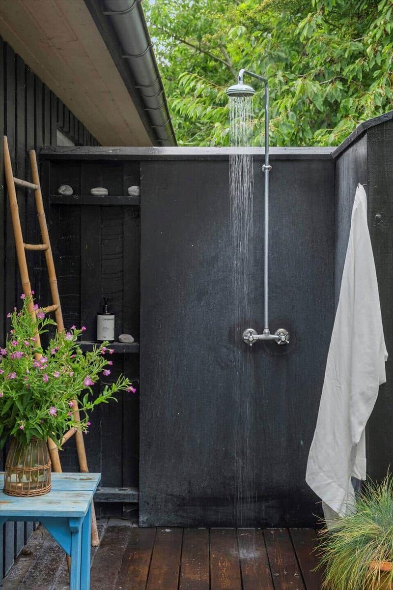 Außendusche mit Regenrinnen und Pflanzen im Garten