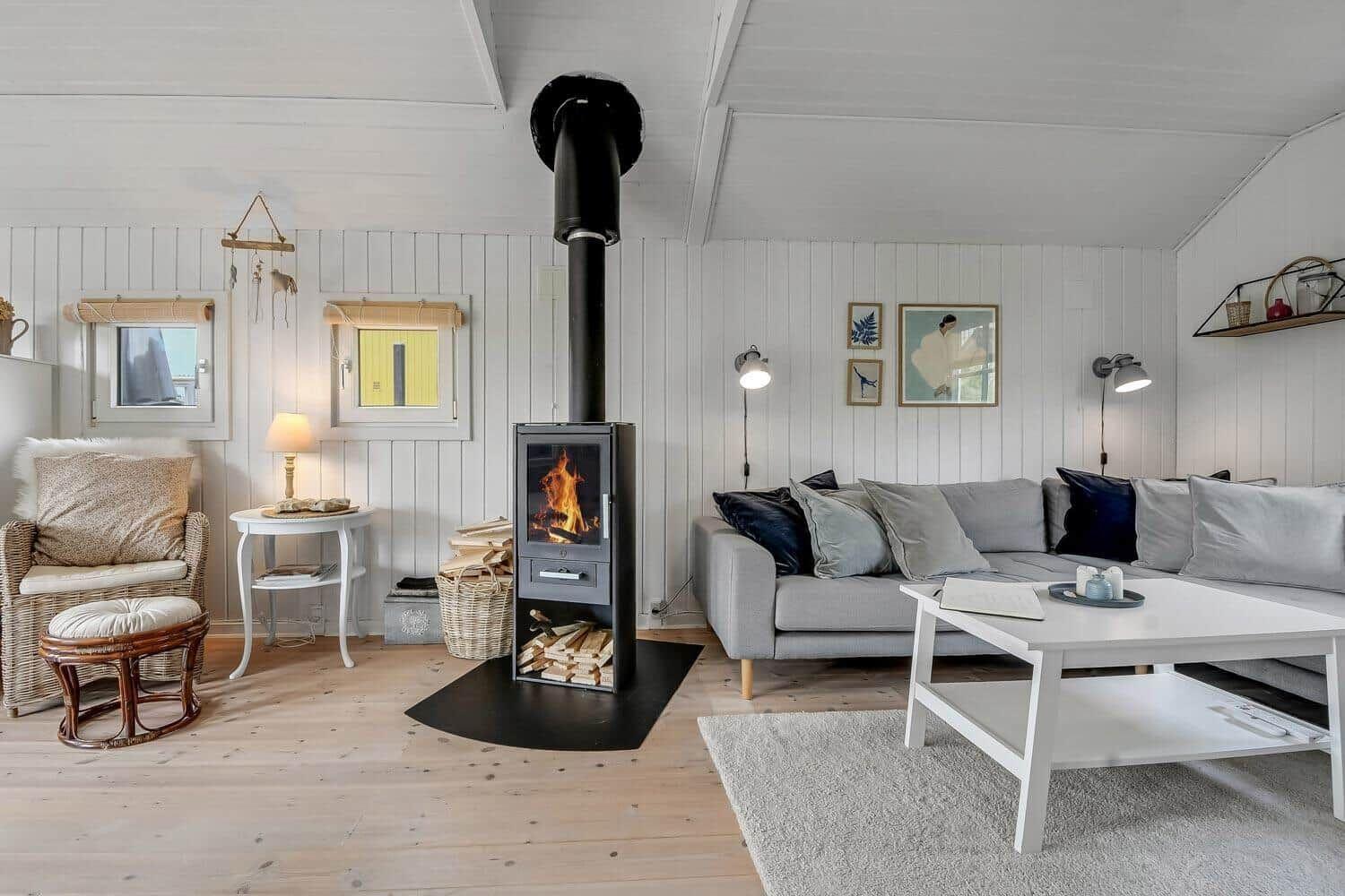Wohnzimmer mit Kamin, Sofa und Holzboden
