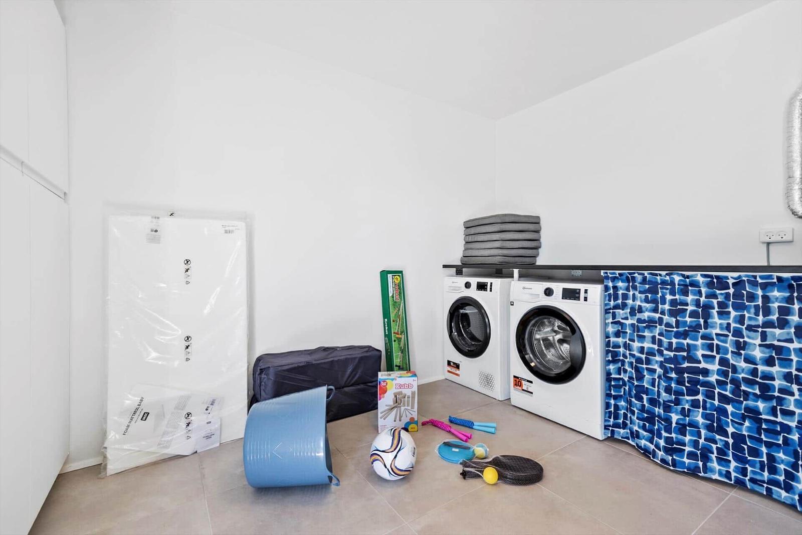 Wäscheschränke, Waschmaschine und Spielzeug in einem Raum.