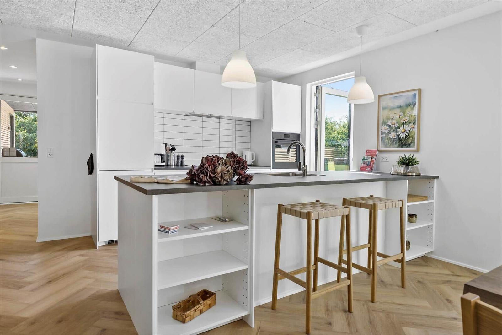 Moderne Küche mit weißem Schrank und Kücheninsel mit Sitzgelegenheit.