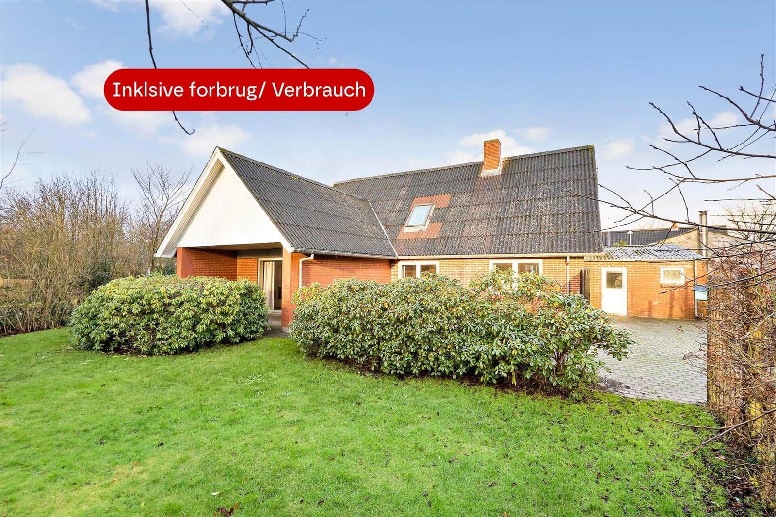 Rotes Backsteingebäude mit Dachgaube und Garten