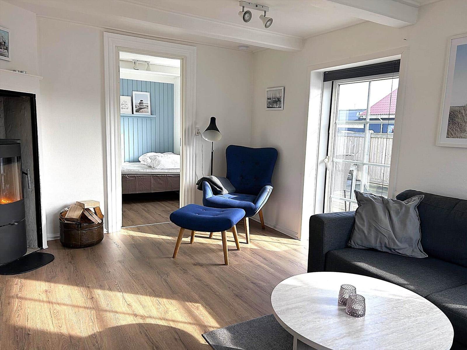 Wohnzimmer mit Sofa, Sessel und Kamin. Durchgang zur Schlafzimmer.