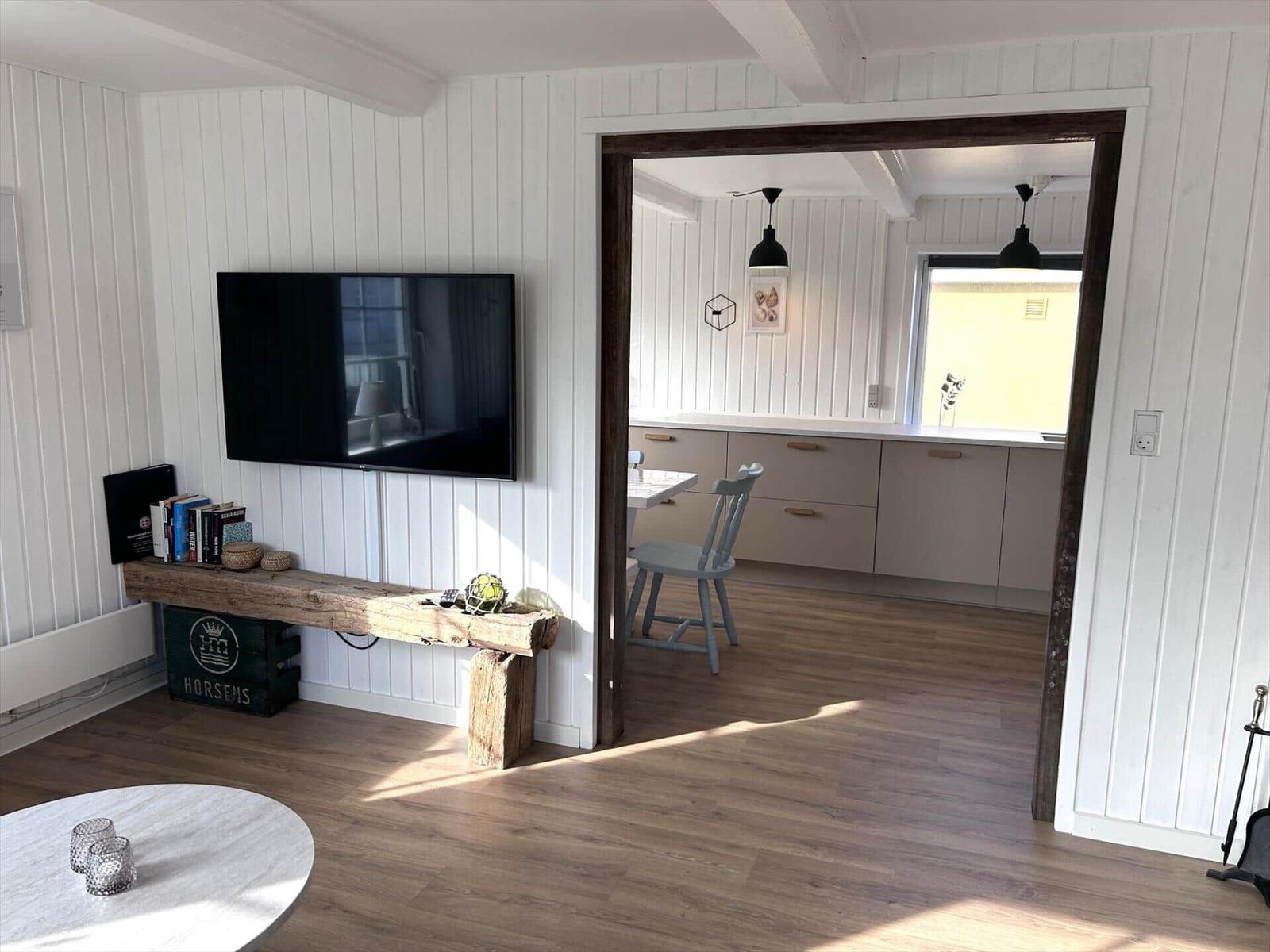 Wohnzimmer mit TV und Blick in die Küche