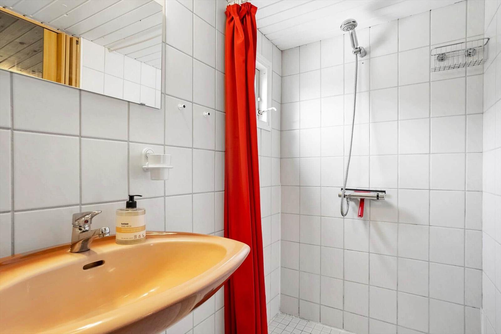 Bad mit Dusche, Waschbecken und Spiegel