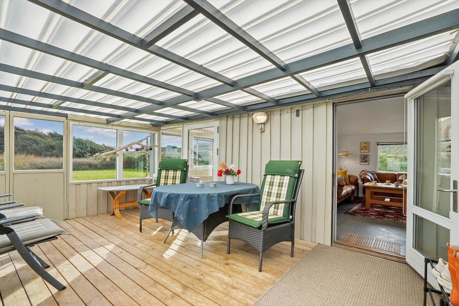 Terrasse mit Tisch, Stühlen und Blick auf Grünland.