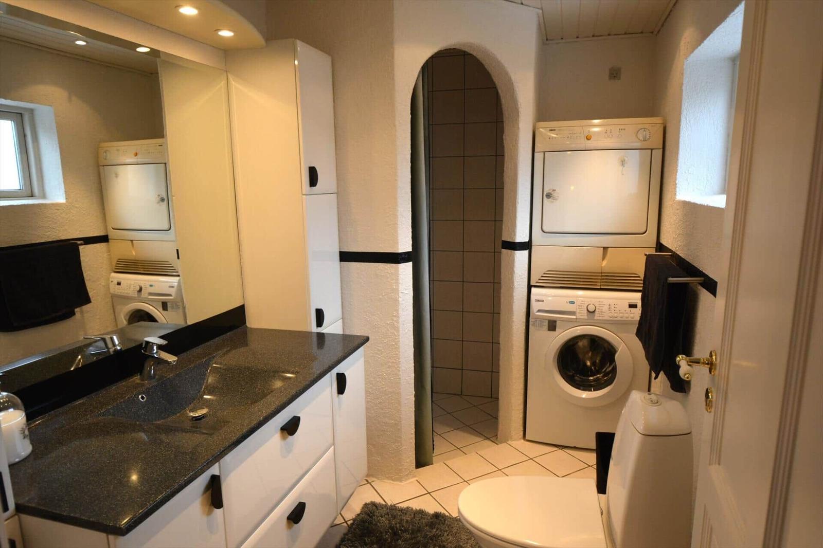 Badezimmer mit Waschmaschine, Trockner und Dusche