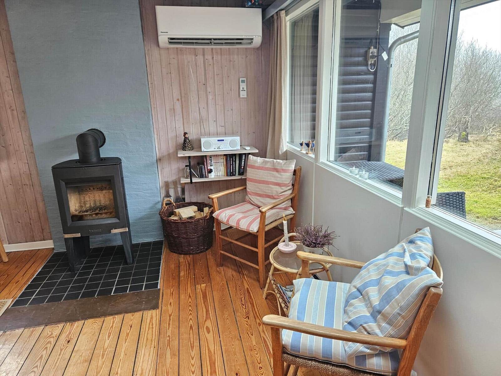 Raum mit Kamin, Stühlen und Blick auf Außenbereich