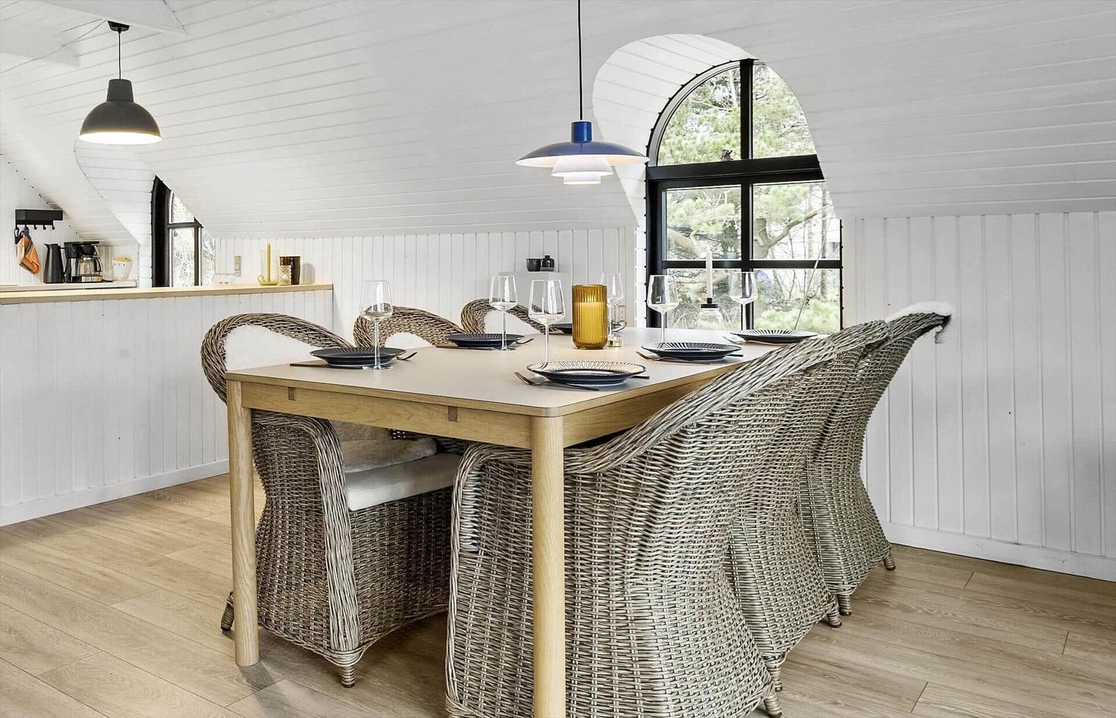 Essbereich mit Esstisch und Stühlen unter einem weißen Dach.