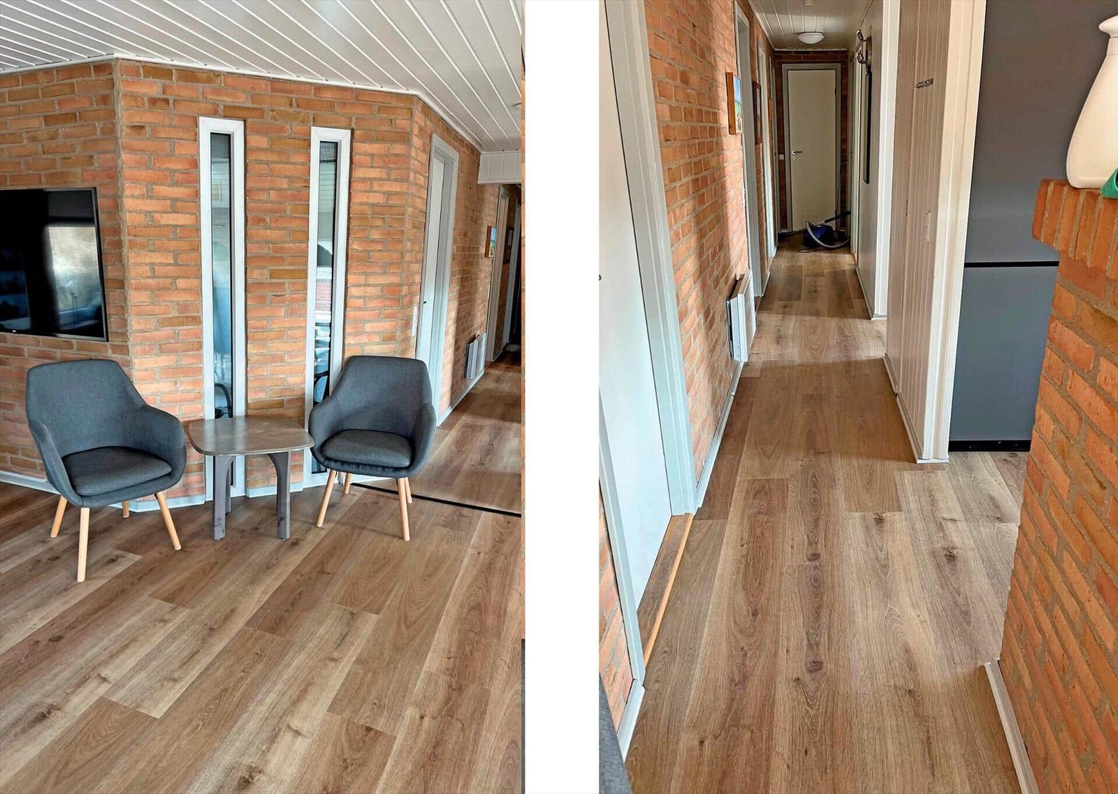 Flur mit Holzfußboden und Backsteinwand. Links Sitzbereich mit zwei Stühlen und Tisch.