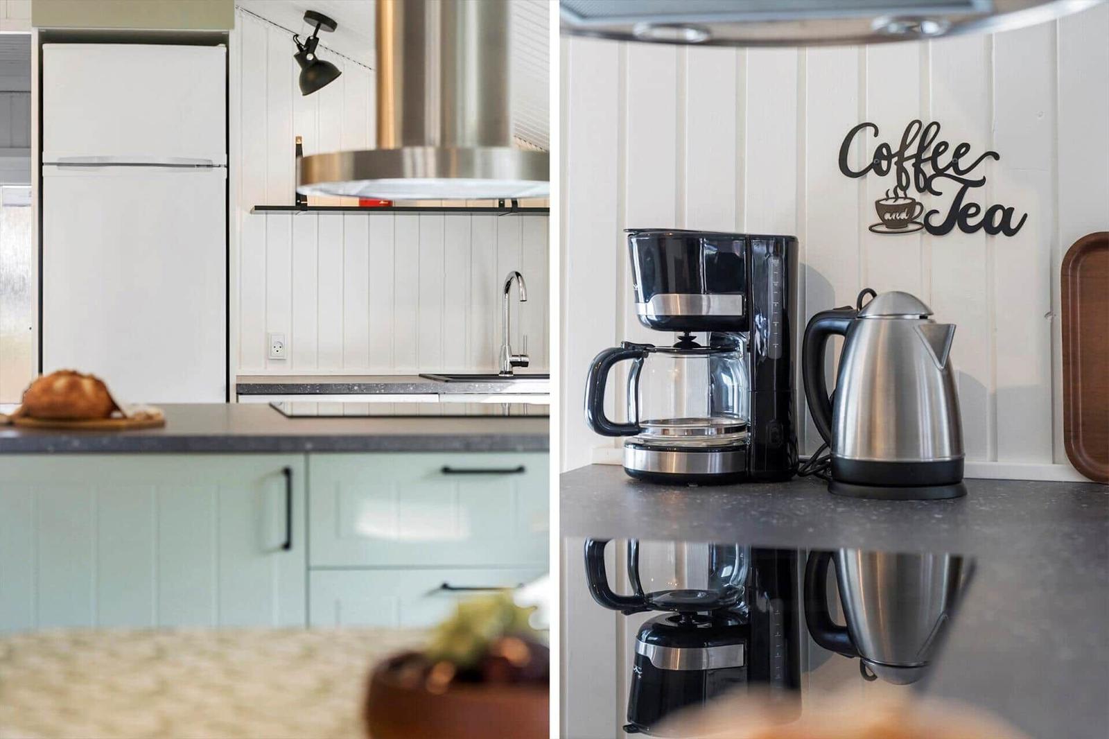 Küche mit Kühlschrank, Spüle und Kaffeemaschine. Wanddekoration mit Schriftzug.