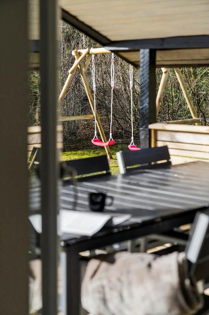 Außenbereich mit Tisch, Stühlen und Schaukel