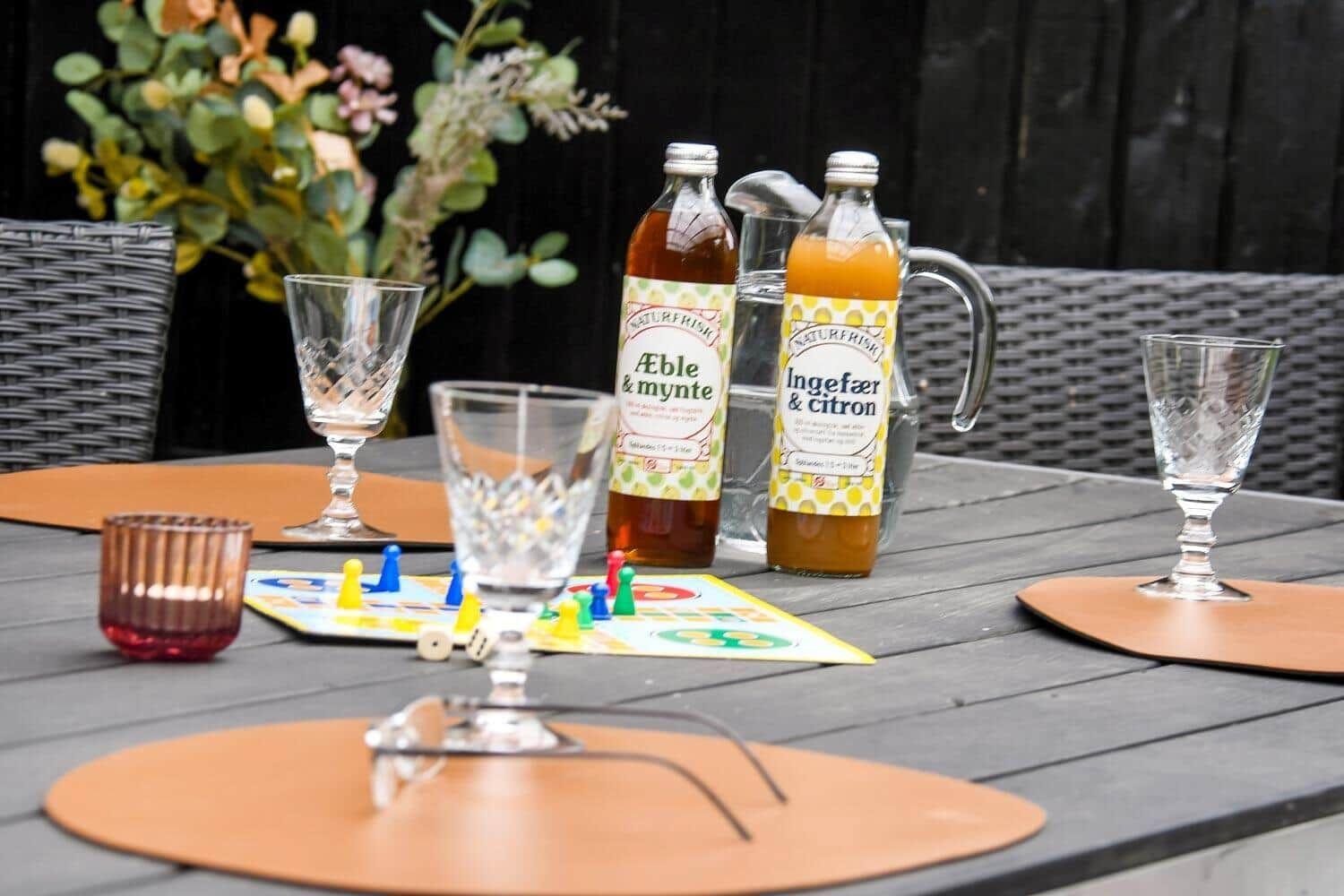 Außenbereich mit Tisch, Gläsern, Flaschen und Spielzeug.
