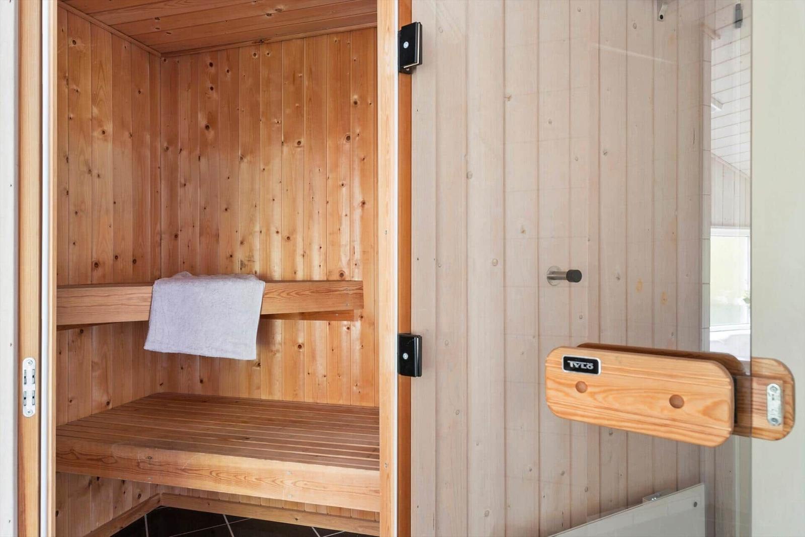 Holzsauna mit Sitzbank und Handtuch