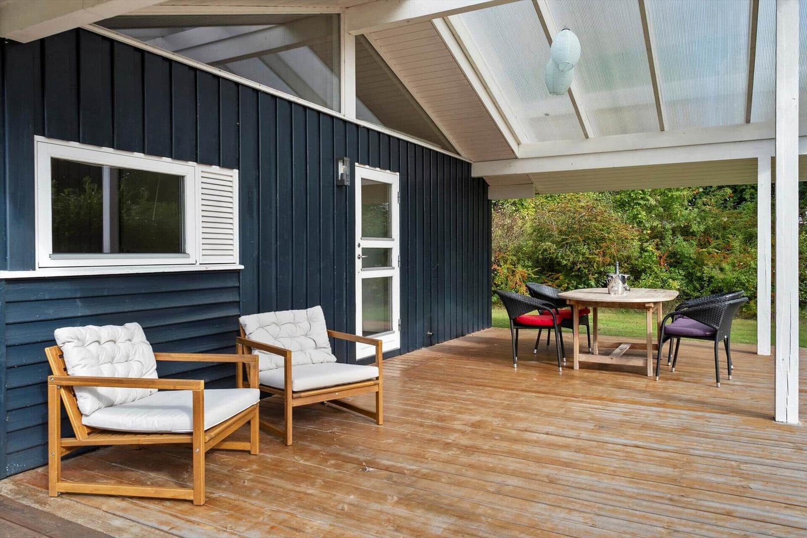 Terrasse mit Holzdielen, Sitzgelegenheiten und Blick in den Garten.