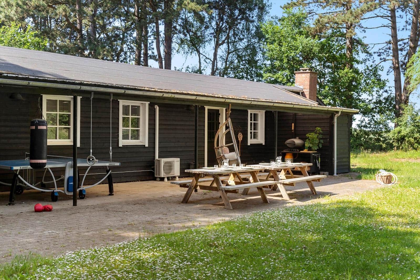 Haus mit Garten, Picknicktisch, Schaukel und Tischtennisplatte.