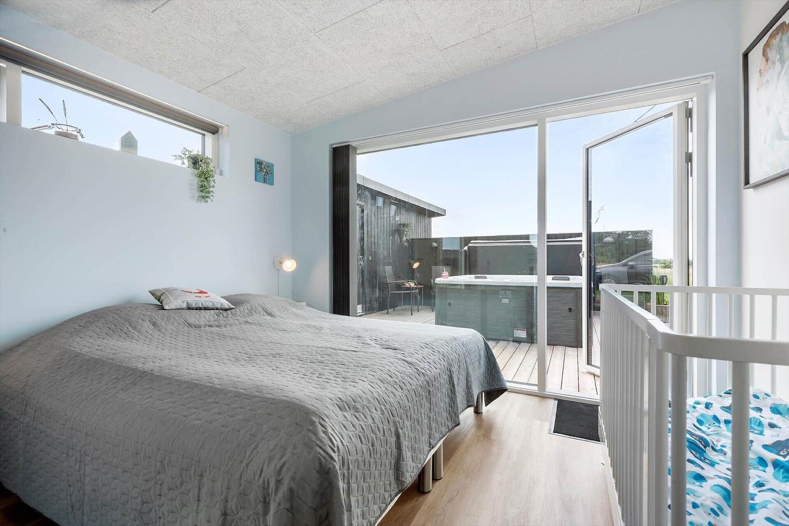 Schlafzimmer mit Blick auf Whirlpool und Balkon