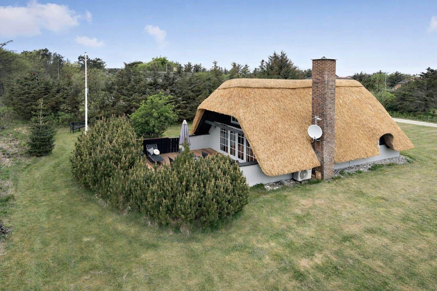 Dorfhaus mit Strohdach, Terrasse und Grillplatz im Grünen.
