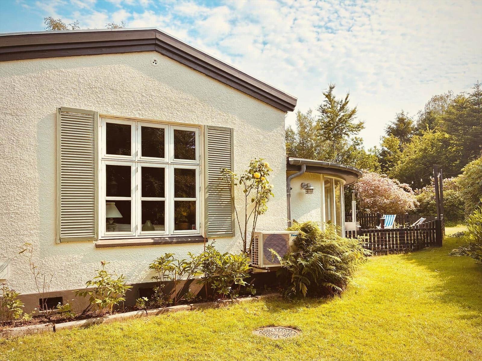 House with garden, windows with shutters and air conditioner