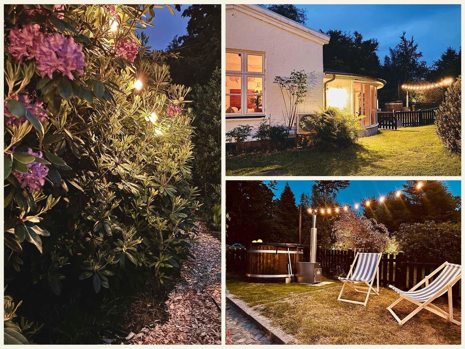 House with garden, hot tub, and lounge chairs at night with string lights.