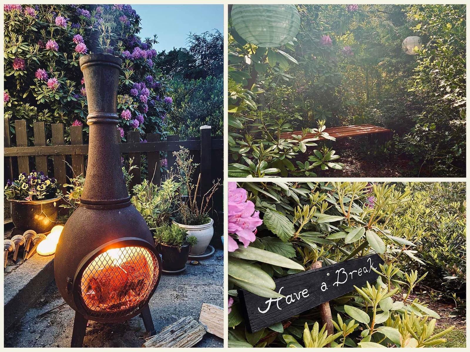 Outdoor area with chiminea, bench, and flower beds in the garden.