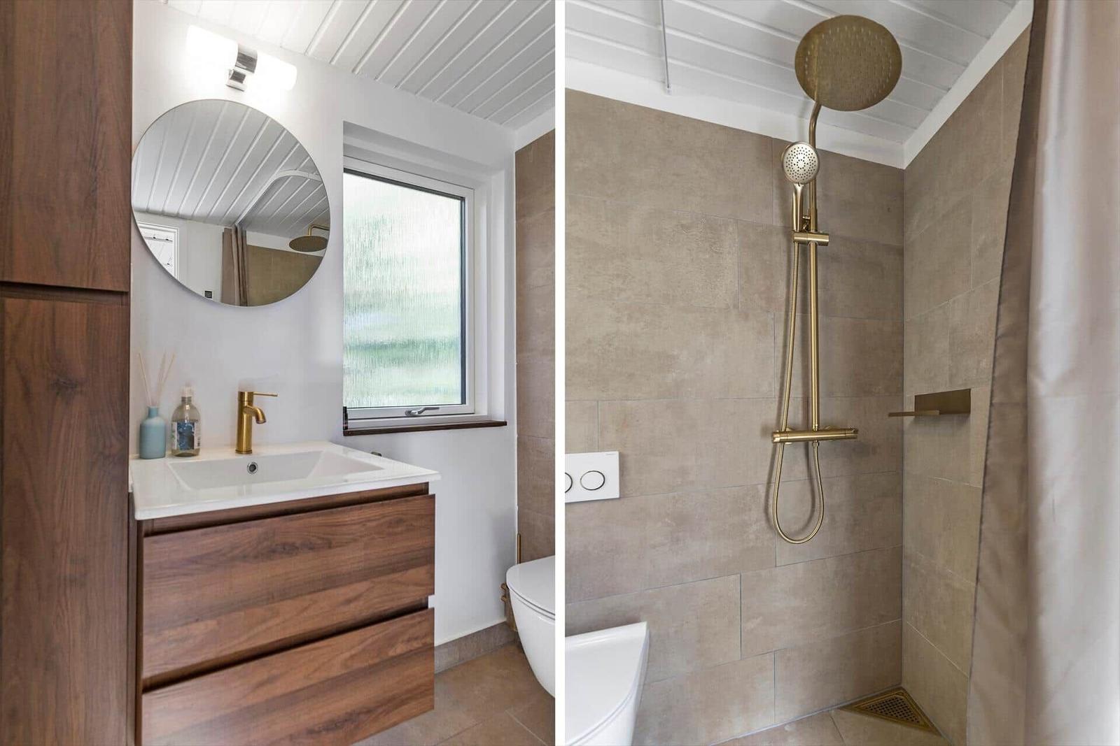 Badezimmer mit Waschbecken, Dusche und Toilette. Holzunterschrank und goldfarbene Duschkopf.