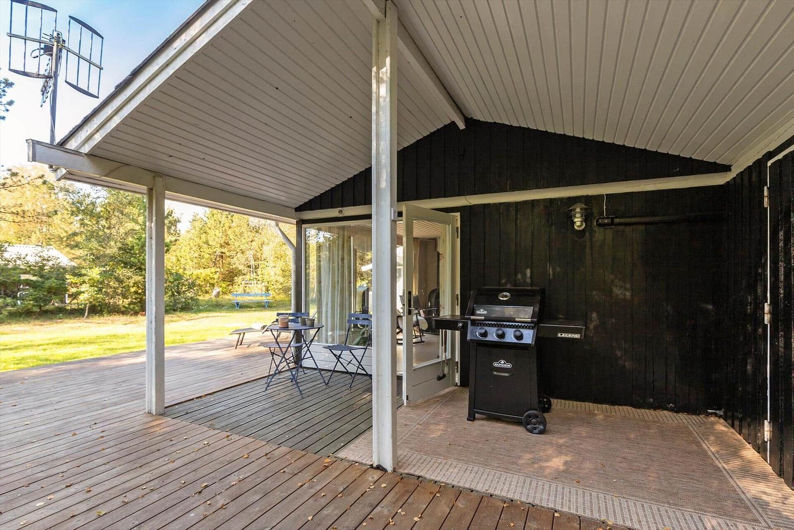 Terrasse mit Grill und Sitzgelegenheit unter Dach