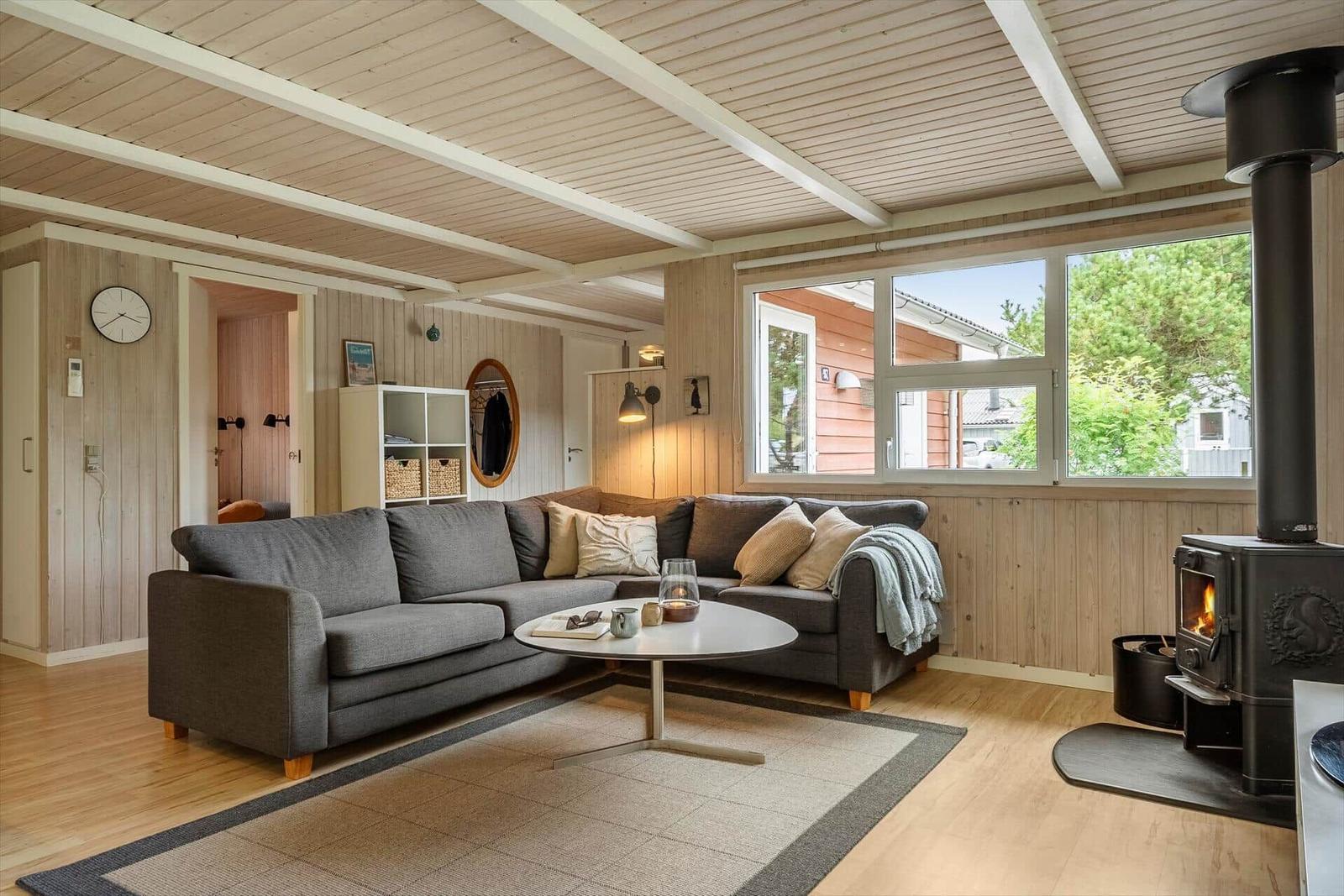Wohnzimmer mit Sofa, Kamin und Fensterblick