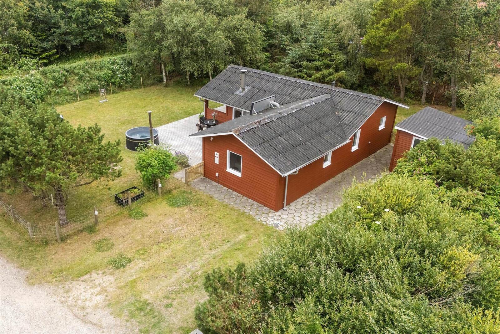 Rotes Holzhaus mit Pool und Terrasse im Grünen