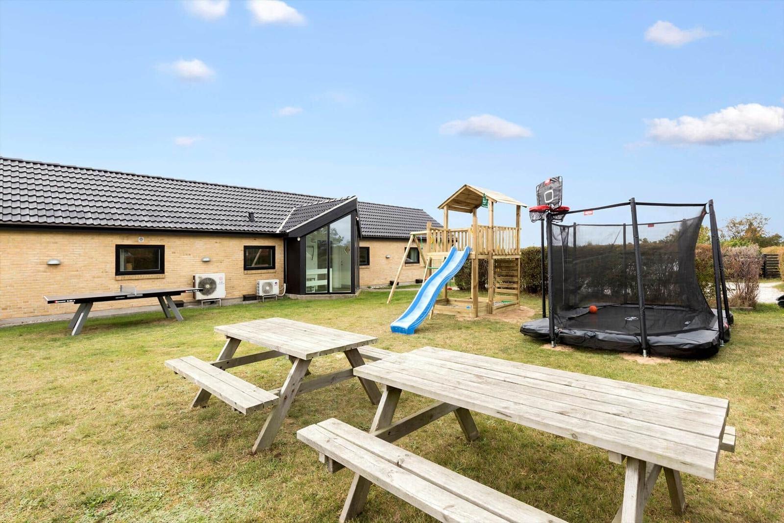 Hinter dem Haus befinden sich Spielplatz, Trampolin und Picknicktische.