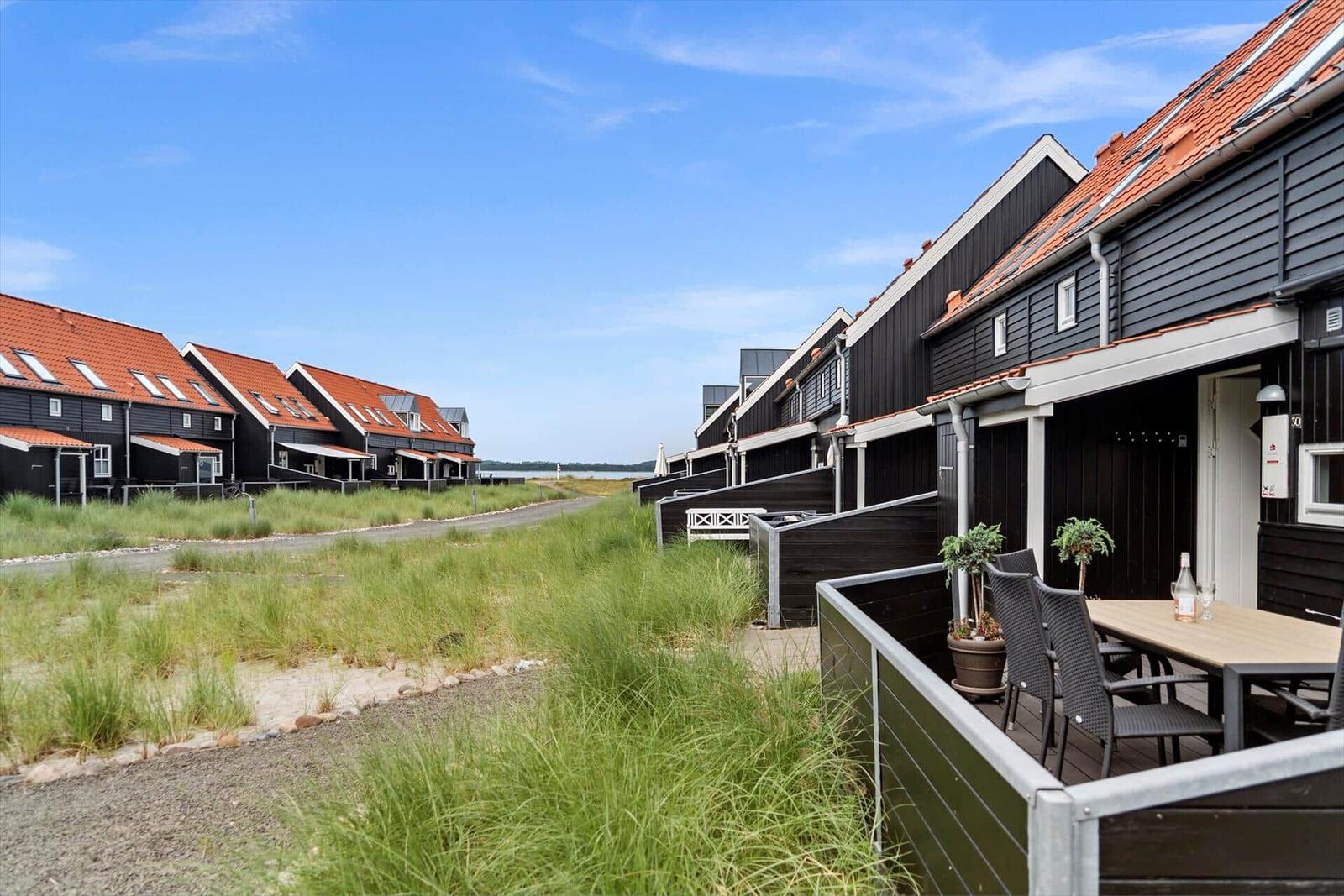 Reihen von Ferienhäusern mit Terrassen und roten Dächern am Strand