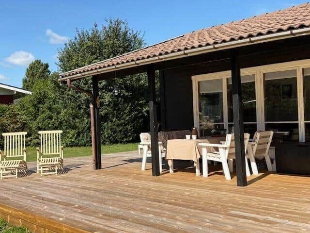 Deck with table, chairs, and seating under roof
