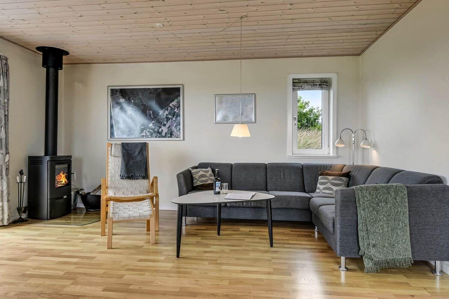 Wohnzimmer mit Sofa, Kamin und Holzboden