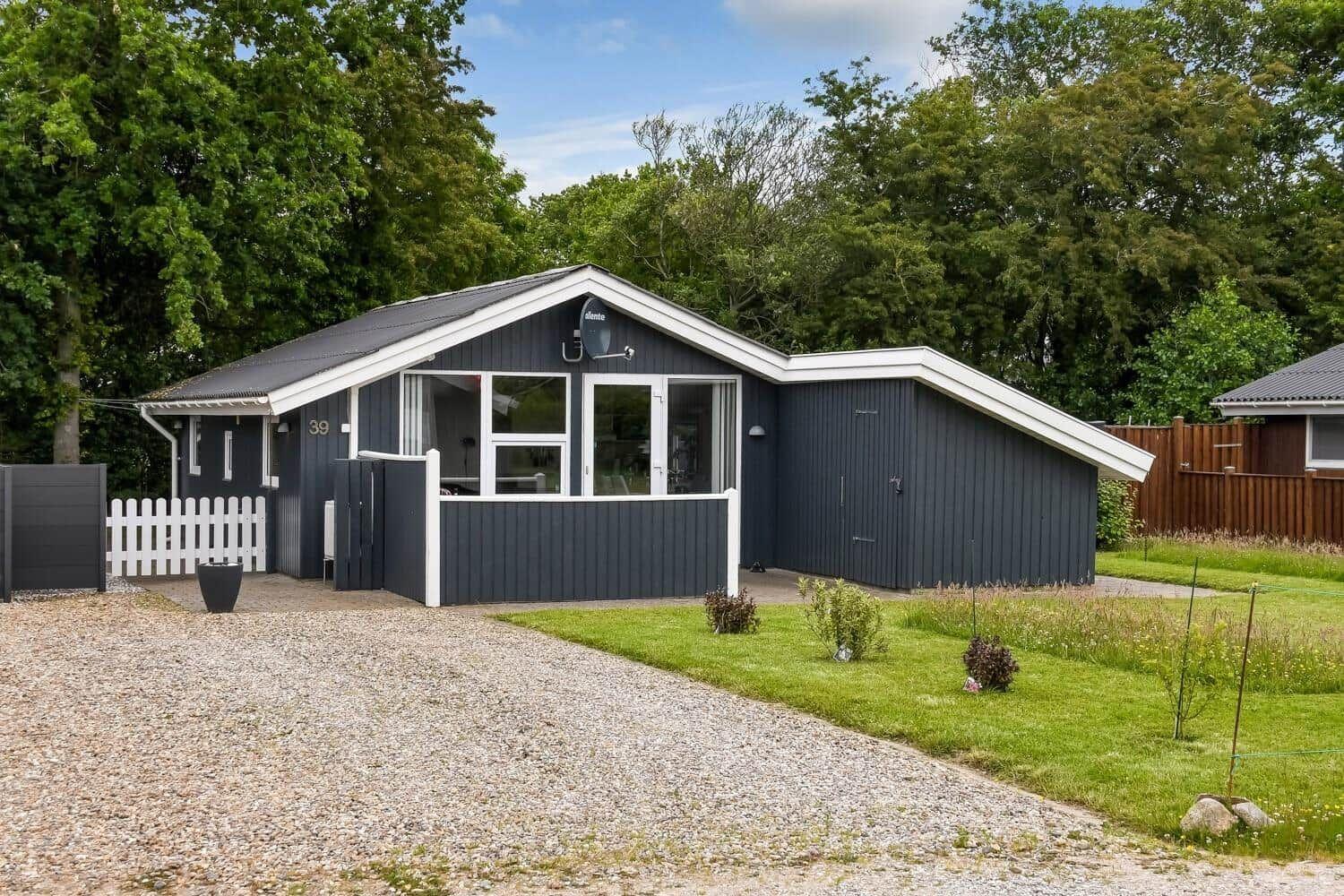 Ein graues Ferienhaus mit weißem Rahmen und Garten. Hausnummer 39.