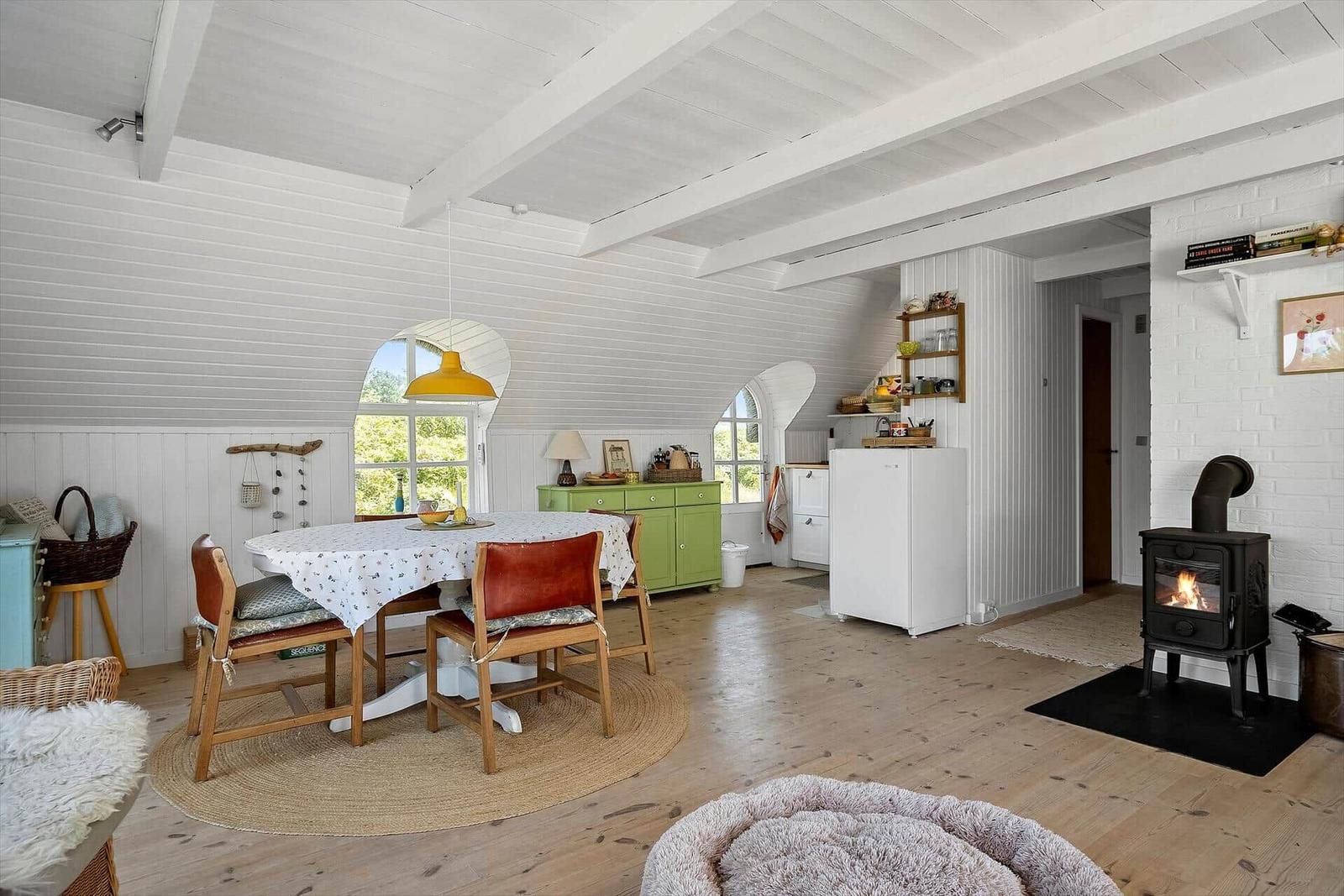 Esszimmer mit Holzboden, Kamin und grüner Schrank
